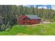 Exterior view of a red two-story home with a green roof and spacious deck at 27612 Shadow Mountain Dr, Conifer, CO 80433