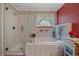 Main bathroom features a glass shower, bathtub, vanity, and window with a view to the yard at 27612 Shadow Mountain Dr, Conifer, CO 80433