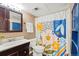 Functional bathroom featuring a dark vanity, commode, and tub with a floral curtain at 12142 Bannock Cir # B, Denver, CO 80234