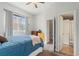 Bright bedroom featuring a ceiling fan, window, dressers, and en-suite bathroom access at 12142 Bannock Cir # B, Denver, CO 80234