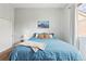 Inviting bedroom featuring a soft blue bedspread, mountain print and soft natural lighting at 12142 Bannock Cir # B, Denver, CO 80234