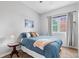 Cozy bedroom with blue bedding, side table, mountain artwork, window, and neutral walls at 12142 Bannock Cir # B, Denver, CO 80234