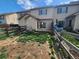 View of the backyard with a rustic fence, small patio, and sliding door at 12753 Ivanhoe St, Thornton, CO 80602