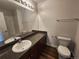 Bathroom with granite-style countertop, a big mirror, and a toilet with a bathtub shower combo at 12753 Ivanhoe St, Thornton, CO 80602
