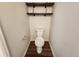 Clean half-bathroom with modern toilet, wooden shelves, and neutral-toned walls at 12753 Ivanhoe St, Thornton, CO 80602