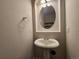 Cozy half-bathroom featuring pedestal sink, framed mirror, and neutral wall color at 12753 Ivanhoe St, Thornton, CO 80602