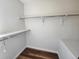 Empty closet with laminate floors, white walls, and metal shelves providing storage and organization at 12753 Ivanhoe St, Thornton, CO 80602