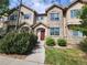 Charming townhome with stone accents, a manicured lawn, and a welcoming front entrance at 12753 Ivanhoe St, Thornton, CO 80602