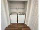 Convenient laundry closet featuring a modern washer and dryer on a wood floor, and shelf for storage at 12753 Ivanhoe St, Thornton, CO 80602