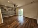 Open living room with modern ceiling fan, wood-paneled wall, and access to backyard at 12753 Ivanhoe St, Thornton, CO 80602