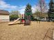 Community playground featuring a slide, climbing stairs, and swing set on a wood chip surface at 12753 Ivanhoe St, Thornton, CO 80602