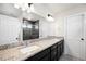Granite-topped double sink bathroom vanity with large mirrors, modern lighting, and walk-in shower at 21925 E 44Th Pl, Aurora, CO 80019