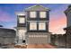 Charming home featuring stone accents, neutral siding, and a two-car garage, all set against a colorful sunset sky at 21925 E 44Th Pl, Aurora, CO 80019