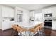 Bright kitchen featuring stainless steel appliances, white cabinets, large island with seating, and modern finishes at 21925 E 44Th Pl, Aurora, CO 80019
