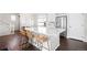 Bright kitchen features an island with barstool seating, white cabinetry, stainless steel appliances, and hardwood floors at 21925 E 44Th Pl, Aurora, CO 80019