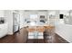 Bright kitchen features an island with barstool seating, white cabinetry, stainless steel appliances, and hardwood floors at 21925 E 44Th Pl, Aurora, CO 80019