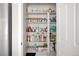 Walk-in pantry with stocked shelves provides ample storage for any homeowner at 21925 E 44Th Pl, Aurora, CO 80019