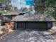 Charming exterior showing a large driveway with a basketball hoop and a two-car garage at 2434 Hearth Dr # C1, Evergreen, CO 80439