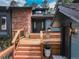 Inviting front entrance featuring a wood porch with wood steps, stone accents, and potted plants at 2434 Hearth Dr # C1, Evergreen, CO 80439