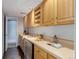 Basement wet bar with light wood cabinets, small refrigerator, and sink at 2434 Hearth Dr # C1, Evergreen, CO 80439