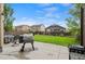 Grassy backyard with patio area, grill, outdoor seating, landscaping, and privacy fence at 5161 Chicory Cir, Brighton, CO 80601