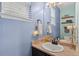 Charming powder room with blue walls, a stylish mirror, and a unique decorative touch at 5161 Chicory Cir, Brighton, CO 80601