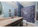 Blue bathroom with eye-catching shower curtain and vanity with framed mirror at 5161 Chicory Cir, Brighton, CO 80601