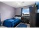 Cozy bedroom with light purple walls, a ceiling fan, and large window at 5161 Chicory Cir, Brighton, CO 80601