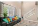 Bright living room featuring large windows, comfortable seating, and a staircase at 5161 Chicory Cir, Brighton, CO 80601