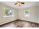 Light-filled bedroom with ceiling fan and two windows showcasing the outdoor scenery at 233 N 10Th Ave, Brighton, CO 80601
