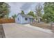 Exterior view of a cozy blue home with a spacious concrete driveway and fenced yard at 233 N 10Th Ave, Brighton, CO 80601