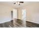Bright living room with dark wood-look floors and a ceiling fan, creating a comfortable space at 233 N 10Th Ave, Brighton, CO 80601