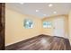 Bright living room with stylish wood floors, natural light, and a white accent door at 233 N 10Th Ave, Brighton, CO 80601