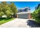 Two-story home with brick accents, gray garage door, and well-maintained lawn and mature trees at 4894 E Ashton Ave, Castle Rock, CO 80104