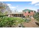 Beautiful backyard showcasing a brick home, inviting patio, and lush garden under a blue sky at 588 Newark St, Aurora, CO 80010