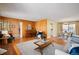 Open living room with hardwood floors connecting the dining area and featuring a brick fireplace at 588 Newark St, Aurora, CO 80010