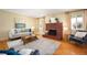 Inviting living room featuring a brick fireplace, hardwood floors, and abundant natural light at 588 Newark St, Aurora, CO 80010