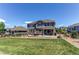 Spacious backyard with lush green grass, landscaping, and outdoor seating areas at 25338 E Costilla Pl, Aurora, CO 80016