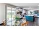 Sunlit dining area featuring a glass-top table, modern lighting, and a view of the backyard at 25338 E Costilla Pl, Aurora, CO 80016
