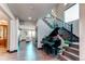 Elegant foyer showcasing a grand piano and staircase with rod iron handrail at 25338 E Costilla Pl, Aurora, CO 80016