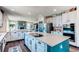 Well-lit kitchen with a large island cooktop, stainless steel appliances, and an open view to the living area at 25338 E Costilla Pl, Aurora, CO 80016