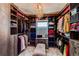 Custom walk-in closet with ample shelving and hanging space, illuminated by a stylish chandelier at 25338 E Costilla Pl, Aurora, CO 80016