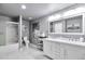 Bright bathroom featuring double vanity, framed mirror, and shower with glass doors at 10639 Worchester Dr, Commerce City, CO 80022