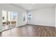 Bright living room with wood floors, large windows, and sliding glass door to backyard at 2161 Flower Blossom Ave, Brighton, CO 80601