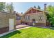 Green backyard featuring a deck, brick garage, and manicured lawn at 618 Milwaukee St, Denver, CO 80206