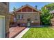 Spacious backyard with a well-maintained lawn, deck, and charming brick exterior at 618 Milwaukee St, Denver, CO 80206