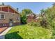 Lush green backyard featuring a brick building, wooden fence and verdant lawn at 618 Milwaukee St, Denver, CO 80206