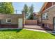 Fenced backyard featuring a deck, brick facade, green grass and detached garage at 618 Milwaukee St, Denver, CO 80206