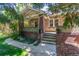 Charming front porch with brick columns and seating area surrounded by mature trees at 618 Milwaukee St, Denver, CO 80206