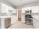 Well-lit kitchen with stainless appliances, ample white cabinetry, and tile floors at 618 Milwaukee St, Denver, CO 80206